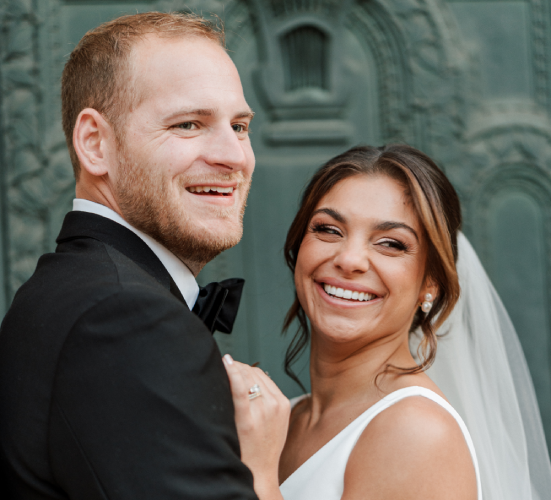 BRITEN customer Cadi B. and her husband laughing on their wedding day with bright white smiles